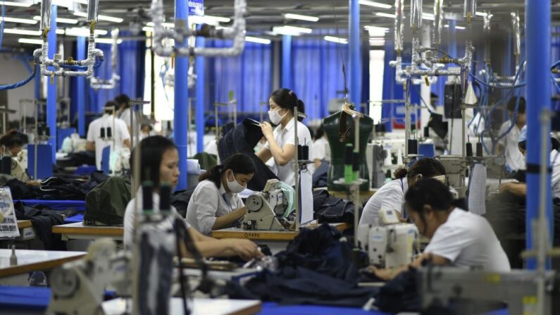 Trabalhadores de fábricas de roupas fazem ternos masculinos em uma fábrica em Hanói, Vietnã, em 24 de maio de 2019 (Manan Vatsyayana / AFP / Getty Images)