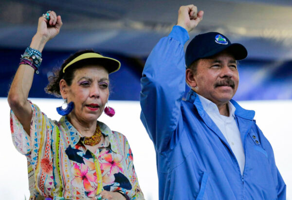 Presidente da Nicarágua, Daniel Ortega, e sua esposa, a vice-presidente Rosario Murillo, erguem os punhos durante a comemoração do 51º aniversário da campanha da guerrilha Pancasan em Manágua em 29 de agosto de 2018. (Inti Ocon / AFP / Getty Images)