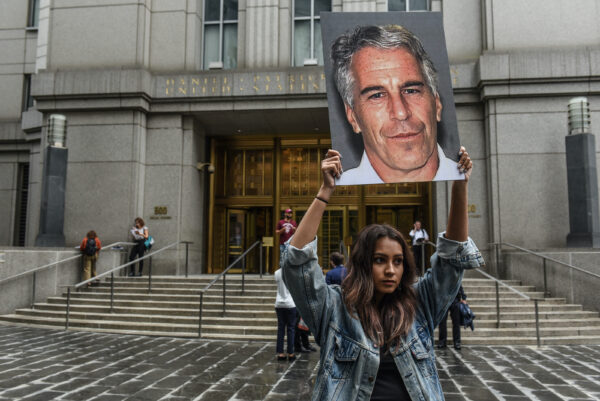 Um manifestante segura uma placa de Jeffrey Epstein em frente ao tribunal federal na cidade de Nova Iorque em 8 de julho de 2019 (Stephanie Keith / Getty Images)