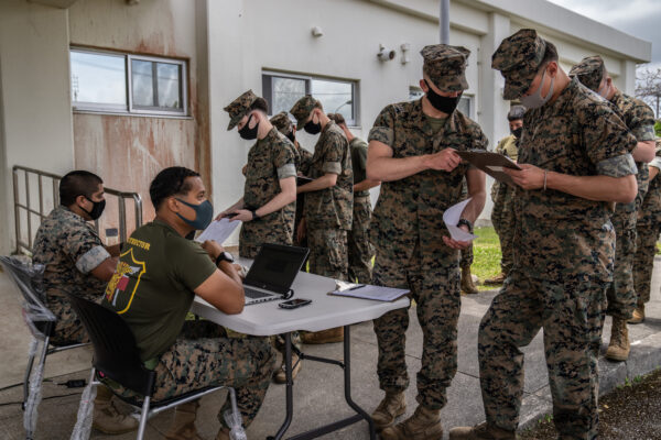 Os fuzileiros navais dos Estados Unidos registram seus dados enquanto fazem fila para receber a vacina da Moderna contra o coronavírus, em Camp Hansen, no dia 28 de abril de 2021, em Kin, no Japão (Carl Court / Getty Images)