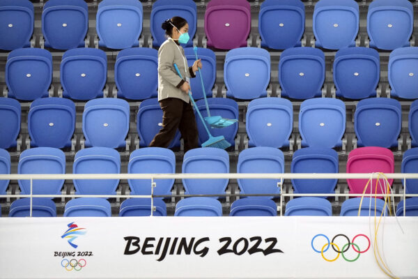  Um trabalhador de manutenção caminha por uma seção vazia de arquibancadas perto de um logotipo dos Jogos Olímpicos de Inverno de 2022 em Pequim, no Oval Nacional de Patinação de Velocidade, em Pequim, no dia 10 de outubro de 2021 (Mark Schiefelbein/AP Photo)