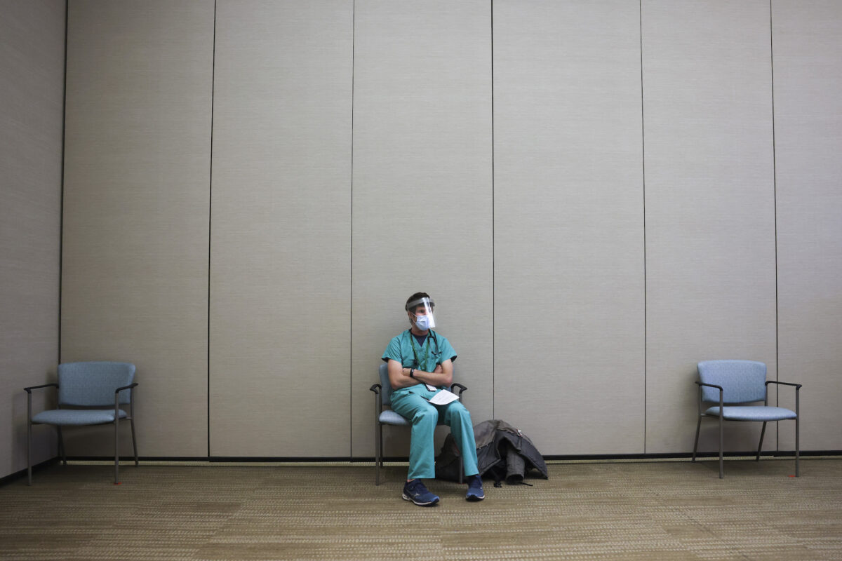 Um residente de medicina fica em uma área de espera antes de receber uma dose da vacina Pfizer-BioNTech contra a COVID-19 em um hospital em Aurora, no Colorado, no dia 16 de dezembro de 2020 (Michael Ciaglo/Getty Images)