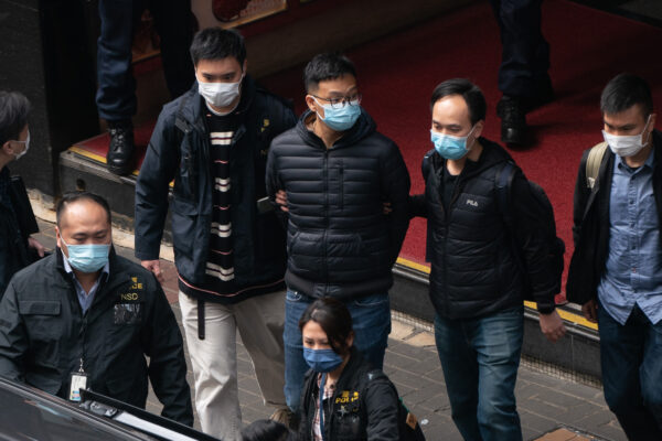O editor-chefe do Stand News, Patrick Lam, é levado a um veículo após a polícia vasculhar as instalações do escritório do veículo de notícias independente em Hong Kong, no dia 29 de dezembro de 2021 (Anthony Kwan / Getty Images)