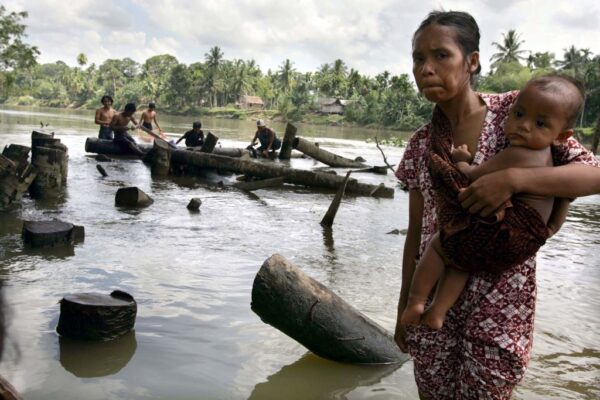 Moradores de um campo para deslocados banham-se em um rio no dia 26 de janeiro de 2005 na cidade de Meulaboh, na Indonésia, devastada pelo tsunami (Spencer Platt / Getty Images)