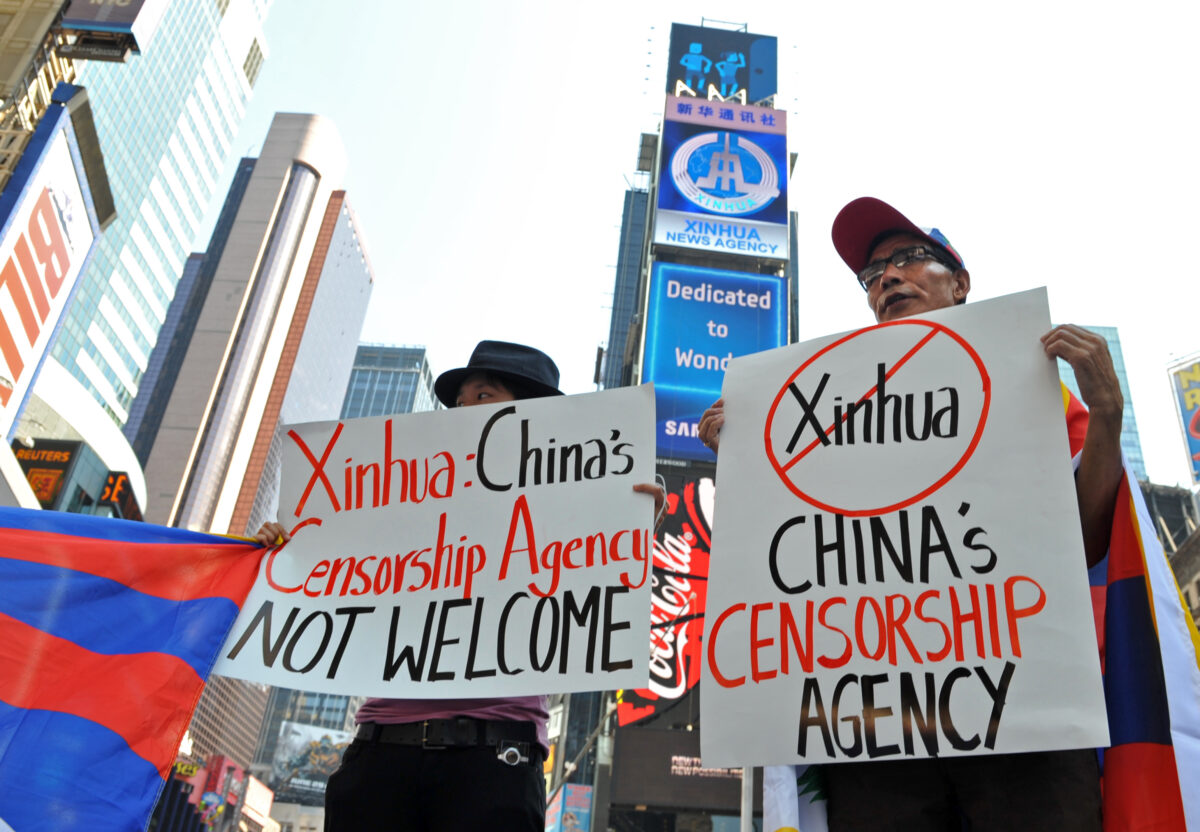 Estudantes por um Tibete Livre protestam abaixo de um novo outdoor eletrônico alugado pela Xinhua (2ª de cima), a agência de notícias operada pelo regime chinês, em sua estreia na Times Square de Nova Iorque, no dia 1º de agosto de 2011 (Stan Honda /AFP via Getty Images)