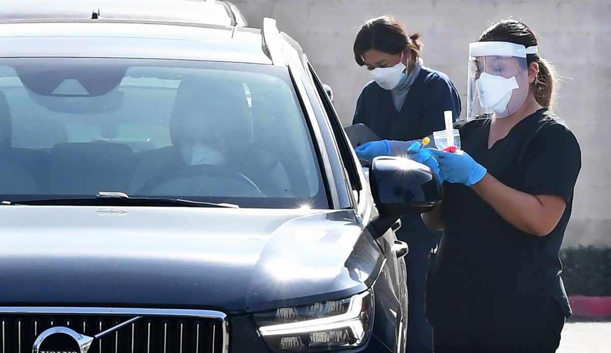 Pessoas são testadas dentro de seus veículos em uma estação de testes para a COVID-19 em Monterey Park, na Califórnia, no dia 14 de janeiro de 2022 (Frederic J. Brown/AFP via Getty Images)
