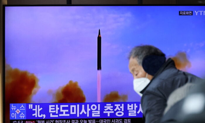 Pessoas assistem a um arquivo de transmissão de TV de uma reportagem sobre a Coreia do Norte disparando um míssil balístico em sua costa leste, em Seul, na Coreia do Sul, no dia 5 de janeiro de 2022 (Kim Hong-Ji/Reuters)