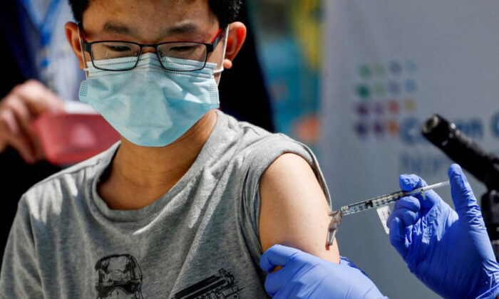Menino de 13 anos recebe a vacina Pfizer-BioNTech contra a COVID-19 em um centro médico no New Hyde Park, em Nova Iorque, no dia 13 de maio de 2021 (Shannon Stapleton/Reuters)
