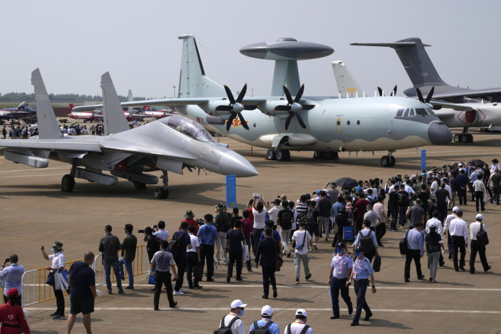 Visitantes observam o avião de guerra eletrônica J-16D dos militares chineses (esquerda) e a aeronave de controle e alerta antecipado KJ-500 (direita) durante a 13ª Exposição Internacional de Aviação e Aeroespacial da China em Zhuhai, província de Guangdong, na China, no dia 29 de setembro der 2021 (Ng Han Guan/AP Photo)