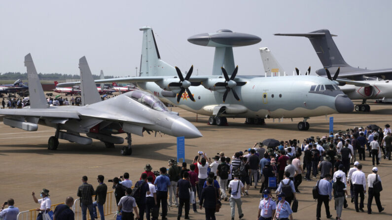 Visitantes observam o avião de guerra eletrônica J-16D dos militares chineses (esquerda) e a aeronave de controle e alerta antecipado KJ-500 (direita) durante a 13ª Exposição Internacional de Aviação e Aeroespacial da China em Zhuhai, província de Guangdong, na China, no dia 29 de setembro der 2021 (Ng Han Guan/AP Photo)