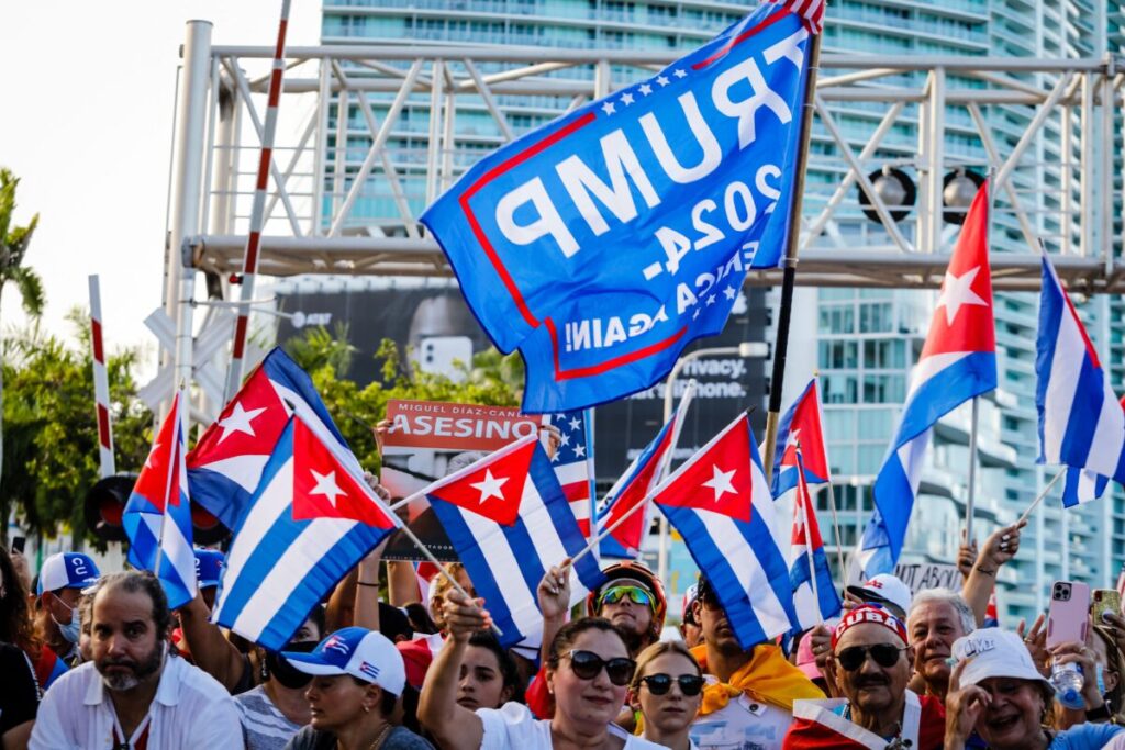  Uma bandeira de Trump 2024 é vista enquanto pessoas agitam bandeiras cubanas e norte-americanas durante uma manifestação de apoio aos cubanos que se manifestam contra a ditadura comunista, na Freedom Tower, em Miami, em 17 de julho de 2021 (Eva Marie Uzcategui/AFP via Getty Images)
