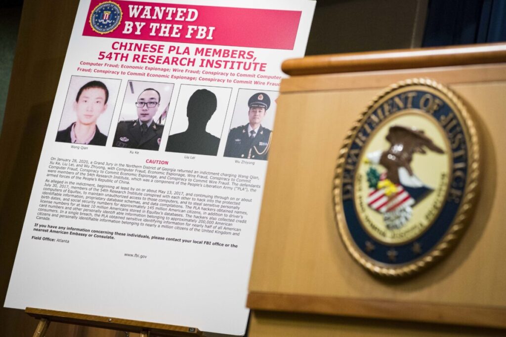 Sinais que retratam os quatro membros das forças armadas da China acusados ​​de invadir a Equifax Inc. e roubar dados de milhões de americanos são vistos no Departamento de Justiça em Washington, no dia 10 de fevereiro de 2020 (Sarah Silbiger/Getty Images)