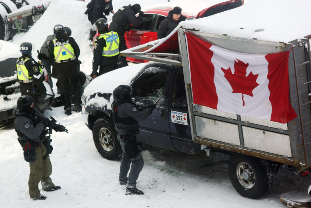 Um policial quebra uma janela de caminhão enquanto a polícia se mobiliza para remover manifestantes em Ottawa, no dia 19 de fevereiro de 2022 (Dave Chan/AFP via Getty Images)