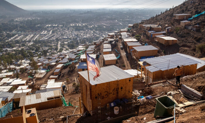 A bandeira chilena voa sobre um acampamento construído por imigrantes haitianos e peruanos, em Lampa, no Chile, no dia 21 de novembro de 2021 (John Moore/Getty Images)
