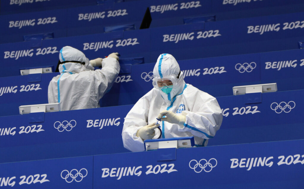 Trabalhadores da arena preparam o local para jogos de hóquei no Estádio Nacional Indoor que antecedem os Jogos Olímpicos de Inverno de Pequim de 2022, em Pequim, no dia 29 de janeiro de 2022 (Bruce Bennett/Getty Images)