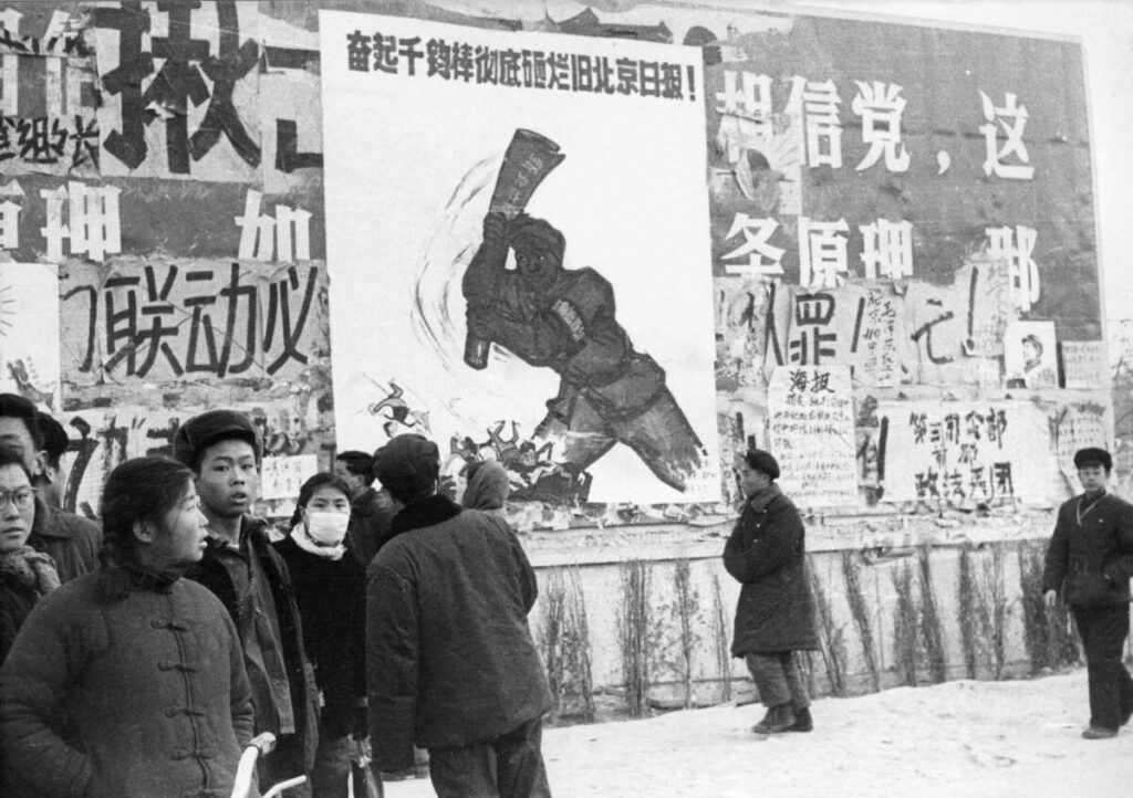 Um pequeno grupo de jovens chineses passa por vários dazibaos, cartazes revolucionários comunistas, no centro de Pequim, durante a Revolução Cultural, em fevereiro de 1967 (Jean Vincent/AFP via Getty Images)