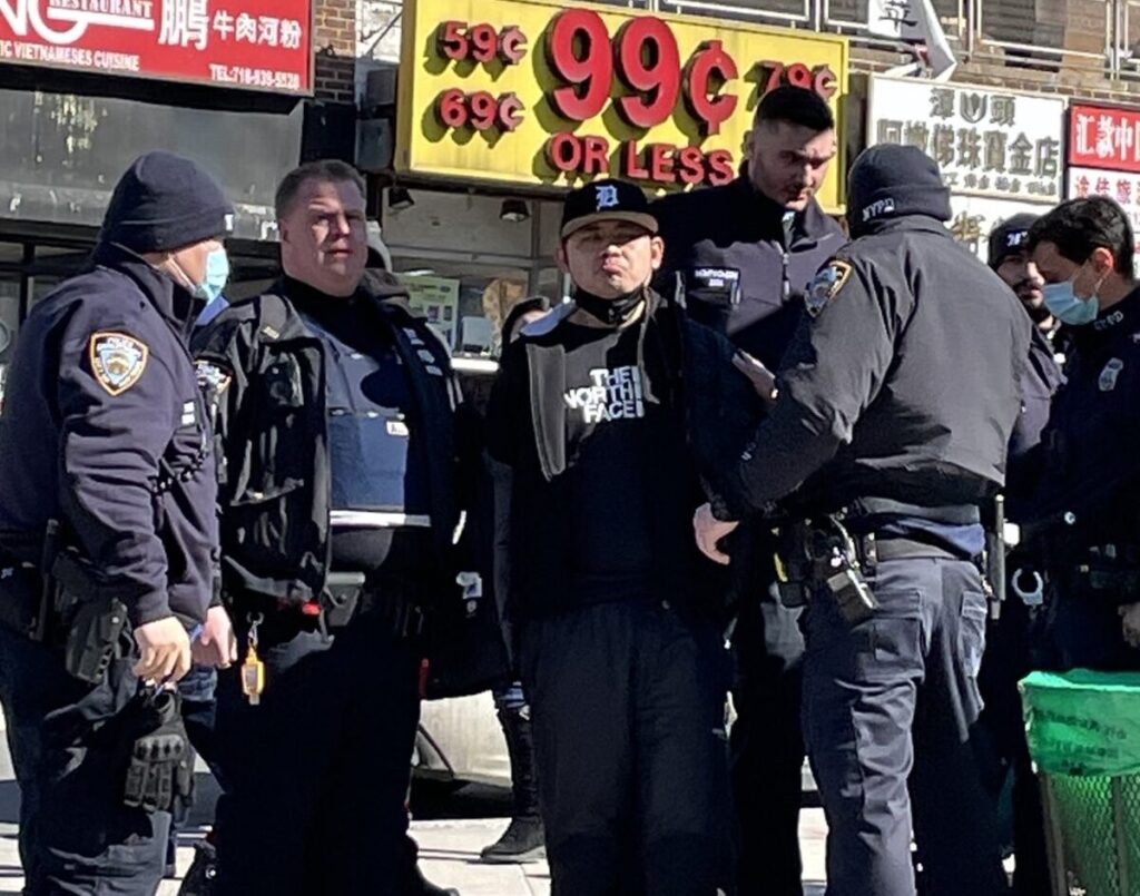A polícia prende Zheng Buqiu por atacar estandes de informação mantidas por praticantes do Falun Gong, em Flushing, Nova Iorque, no dia 15 de fevereiro de 2022 (Fornecido por praticantes do Falun Gong)