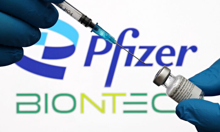 Seringa médica e frascos da corporação farmacêutica americana Pfizer e os logotipos da empresa de biotecnologia alemã BioNTech são vistos na cidade de Nova Iorque no dia 3 de outubro de 2021 (Cindy Ord/Getty Images for Pfizer/BioNTech)