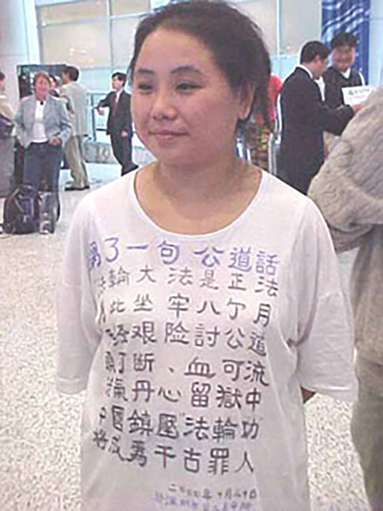 Zhang Cuiying com uma camiseta com um poema expondo a perseguição do PCCh ao Falun Gong, na sala de espera do Aeroporto de Shenzhen, no dia 4 de novembro de 2000 (Cortesia de Zhang Cuiying)