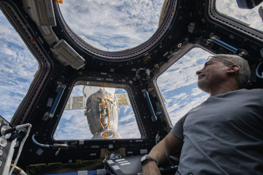 O astronauta americano e engenheiro de voo da Expedição 66, Mark Vande Hei, observa a Terra abaixo de dentro da cúpula de sete janelas, na Estação Espacial Internacional, em 4 de fevereiro de 2022 (Kayla Barron/ NASA via AP)