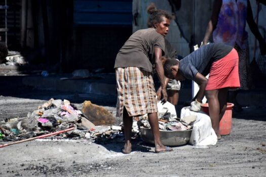 Pessoas limpam destroços das ruas da Chinatown de Honiara, nas Ilhas Salomão, em 28 de novembro de 2021 (Charley Piringi/AFP via Getty Images)