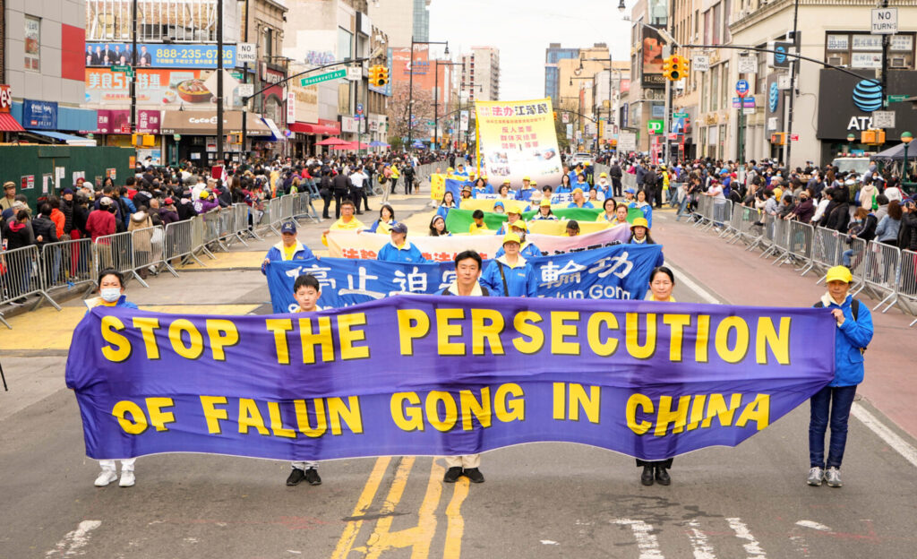  Espectadores se juntam aos praticantes do Falun Gong em um desfile para comemorar o 23º aniversário do apelo pacífico de 10.000 praticantes do Falun Gong em Pequim em 25 de abril, em Flushing, NY, no dia 23 de abril de 2022 (Larry Dye/ Epoch Times)