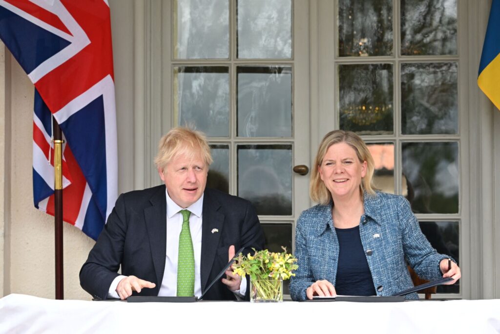 O primeiro-ministro britânico, Boris Johnson, e a primeira-ministra da Suécia, Magdalena Andersson, trocam documentos enquanto assinam uma declaração de solidariedade política na residência de verão do primeiro-ministro sueco em Harpsund, Suécia, em 11 de maio de 2022 (Jonathan Nackstrand/AFP via Getty Images)