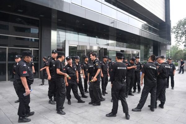 Pessoal de segurança diante da Comissão Reguladora Bancária da China em Pequim, na China, em 6 de agosto de 2018, depois que a polícia chinesa anulou agressivamente um protesto planejado contra perdas sofridas por plataformas de empréstimos peer-to-peer (P2P) (Greg Baker/AFP via Getty Images)