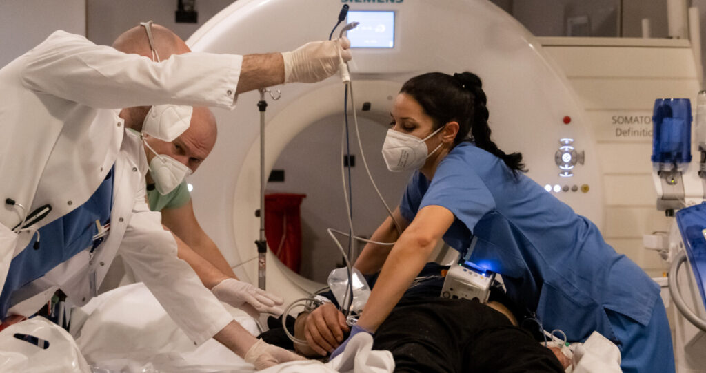 A equipe médica prepara um paciente para uma tomografia computadorizada no principal hospital da cidade de Innsbruck, na Áustria, em 1º de janeiro de 2022 (Jan Hetfleisch/Getty Images)