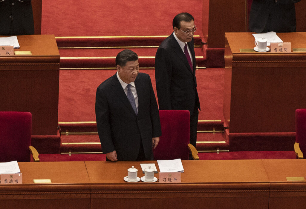 O líder chinês Xi Jinping (C) se prepara para tomar seu assento ao chegar com o primeiro-ministro Li Keqiang na sessão de abertura da Conferência Consultiva Política do Povo Chinês no Grande Salão do Povo em Pequim, na China, em 4 de março de 2022 (Kevin Frayer/Getty Images)