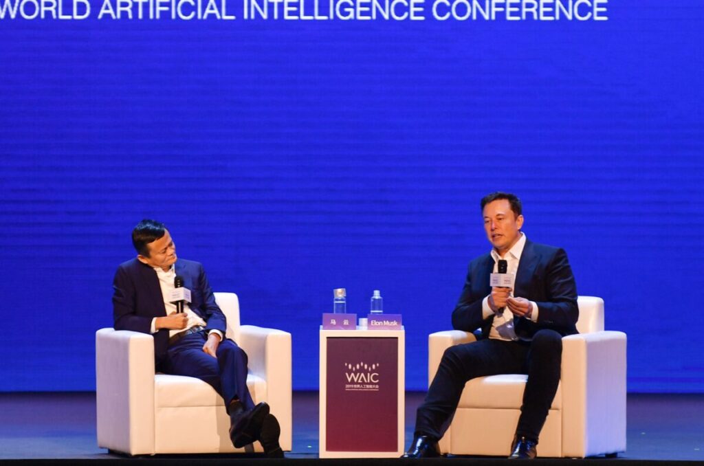 Elon Musk (D), cofundador e CEO da Tesla, e Jack Ma, co-presidente do Painel de Alto Nível da ONU sobre Cooperação Digital, falam no palco durante a Conferência Mundial de Inteligência Artificial (WAIC) em Xangai, em 29 de agosto de 2019 (Hector Retamal/AFP via Getty Images)