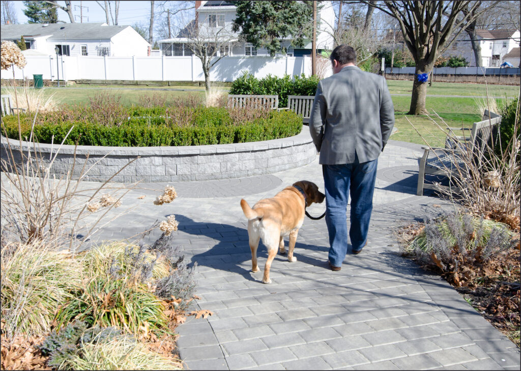 Conor McDonald anda com o cachorro de sua mãe, Murphy, no Jardim do Perdão Steven McDonald, em Malverne, Nova Iorque. Ele vai lá frequentemente, para contemplação silenciosa (Dave Paone/ Epoch TImes)