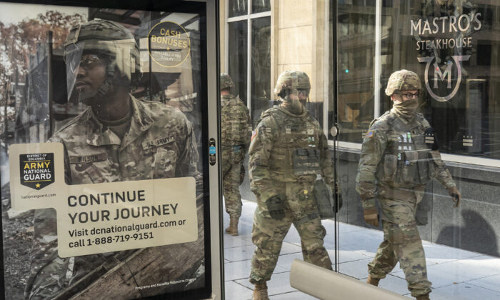 Tropas da Guarda Nacional passam por uma placa de recrutamento para a Guarda Nacional do Exército em Washington, em 19 de janeiro de 2021 (Nathan Howard/Getty Images)