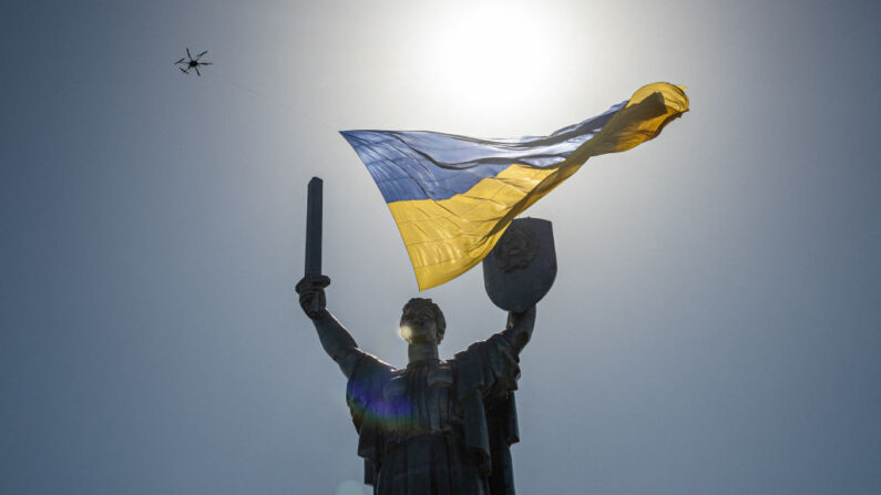 Um drone com uma bandeira nacional ucraniana gigante passa sobre o monumento da Pátria durante o Dia da Independência da Ucrânia em 24 de agosto de 2022, em meio à invasão russa da Ucrânia (Foto de DIMITAR DILKOFF/AFP via Getty Images)