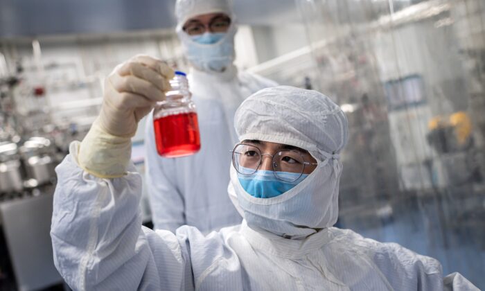 Um engenheiro observa células renais de macacos enquanto faz um teste em uma vacina experimental para o vírus COVID-19 dentro do laboratório da Sala de Cultura de Células nas instalações da Sinovac Biotech em Pequim, China, em 29 de abril de 2020. (Nicolas Asfouri/AFP via Getty Images)