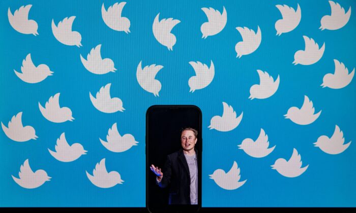 Ilustração de um celular exibindo uma foto de Elon Musk colocada em um monitor de computador cheio de logotipos do Twitter em Washington, D.C., em 5 de agosto de 2022. (Samuel Corum/AFP via Getty Images)