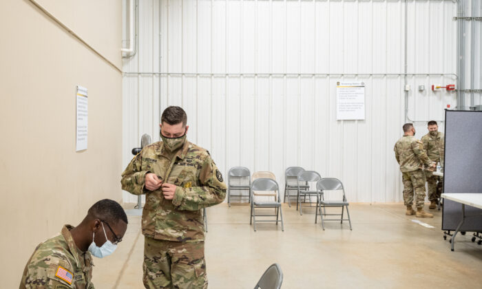 Serviços de medicina preventiva NCOIC Sargento de primeira classe Demetrius Roberson se prepara para administrar uma vacina COVID-19 a um soldado em 9 de setembro de 2021 em Fort Knox, Kentucky. (Jon Cherry/Getty Images)