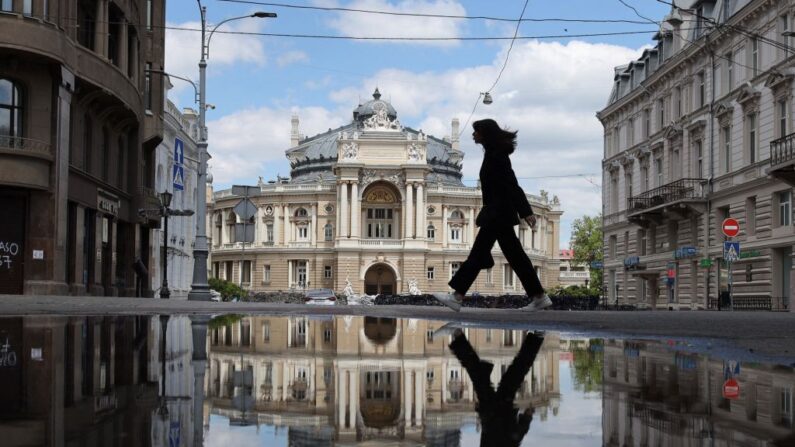 Uma menina reflete em uma poça enquanto caminha na cidade ucraniana de Odessa, no Mar Negro, em 19 de maio de 2022 (Foto de OLEKSANDR GIMANOV/AFP via Getty Images)
