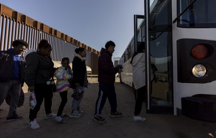 Migrantes caminham em direção a um ônibus que os levará a um centro de processamento após a travessia nos EUA, em Yuma, Arizona, EUA, 11 de maio de 2023 (EFE/EPA/ETIENNE LAURENT)