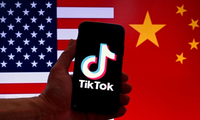 O logotipo do aplicativo de mídia social TikTok é exibido na tela de um iPhone em frente a uma bandeira dos EUA e ao fundo da bandeira chinesa em Washington, em 16 de março de 2023. (Olivier Douliery/AFP via Getty Images)