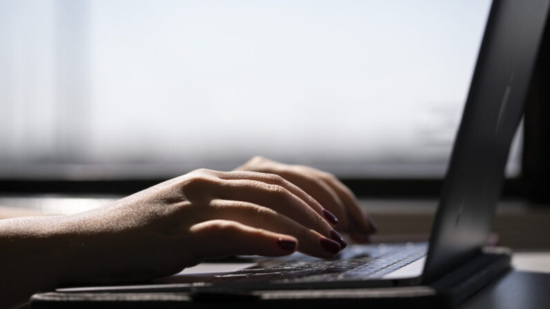 Uma mulher digitando em um laptop. (Foto AP/Jenny Kane)