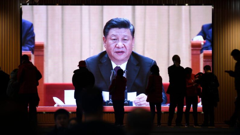 Pessoas passam por uma tela que mostra imagens de vídeo do líder chinês, Xi Jinping, no Museu Nacional da China em Pequim, em 27 de fevereiro de 2019 (Wang Zhao/AFP via Getty Images)
