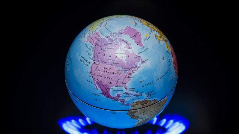 Um pequeno globo acima de uma fogueira para ilustrar o aquecimento global é visto durante a 21ª Sessão da Conferência das Partes da Convenção-Quadro das Nações Unidas sobre Mudança do Clima (COP21/CMP11), na França, em 4 de novembro de 2015. (Lionel Bonaventure/AFP/Getty Images)