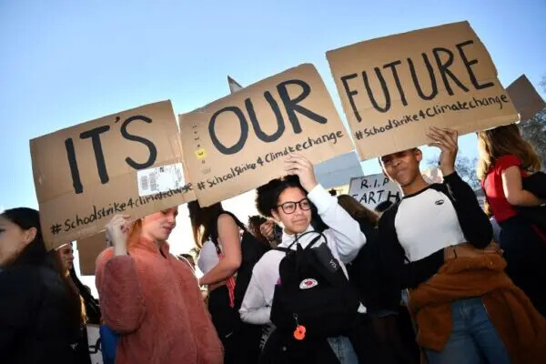 Jovens manifestantes seguram cartazes enquanto participam de um protesto contra as mudanças climáticas em frente às Casas do Parlamento, no centro de Londres, em 15 de fevereiro de 2019 (Ben Stansall/AFP via Getty Images)
