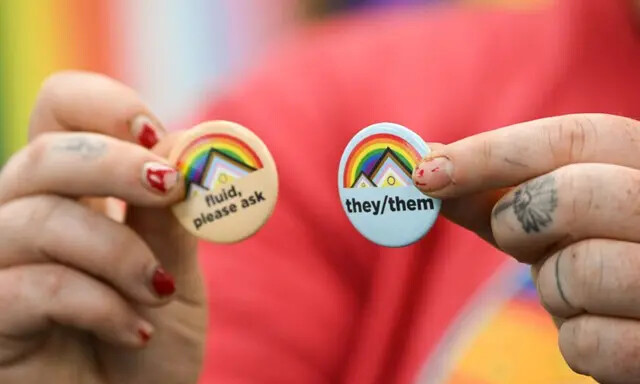 Um ativista LGBT segura broches sobre pronomes de gênero, no campus da Universidade de Wyoming em Laramie, Wyoming, em 13 de agosto de 2022. (Patrick T. Fallon/AFP via Getty Images)
