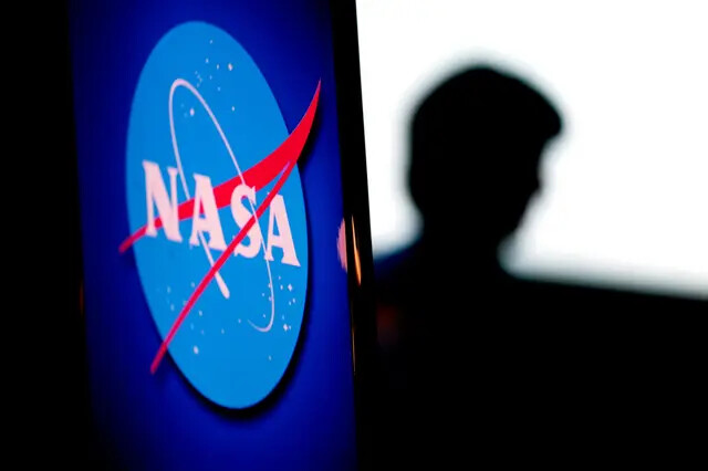 A silhueta da engenheira norte-americana e astronauta da NASA, Megan McArthur, é vista além do logotipo da agência espacial no Auditório Webb na sede da NASA em Washington em 7 de junho de 2022 (Stefani Reynolds/via Getty Images)
