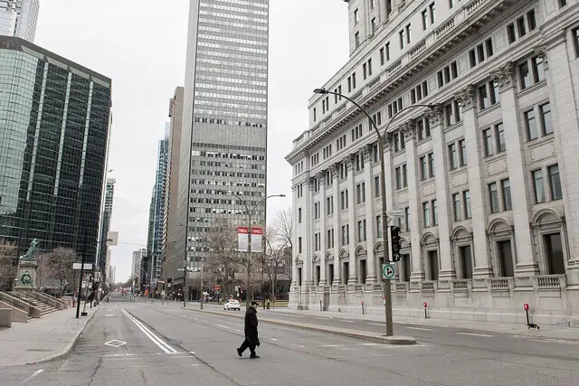 Um homem atravessa uma rua vazia no centro de Montreal durante os lockdowns nacionais no início da pandemia, em 5 de abril de 2020 (The Canadian Press/Graham Hughes)
