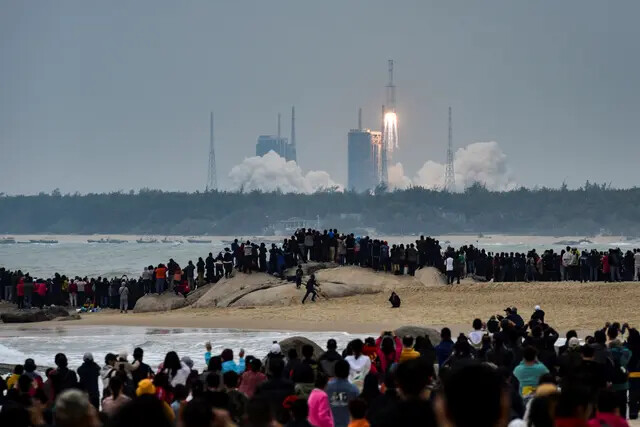 As pessoas assistem ao foguete Long March-8, a mais recente frota de veículos de lançamento da Long March da China, enquanto ele decola do Centro de Lançamento Espacial de Wenchang, na província de Hainan, China, em 22 de dezembro de 2020. (AFP via Getty Images)
