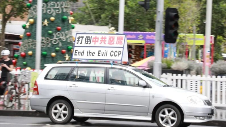 Um carro com a mensagem “Acabe com o Maligno PCCh” em chinês e inglês dirigindo pelas ruas durante um comício anti-Partido Comunista Chinês em Melbourne, Austrália, em 22 de novembro de 2020. (Grace Yu/The Epoch Times)
