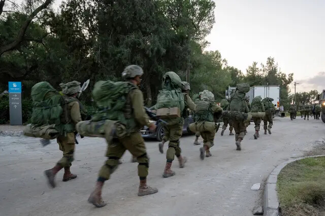 Soldados das Forças de Defesa de Israel caminham pelo Kibutz Be'eri, onde dias antes terroristas do Hamas mataram mais de cem civis perto da fronteira com Gaza em Be'eri, Israel, em 11 de outubro de 2023 (Alexi J. Rosenfeld/Getty Images)